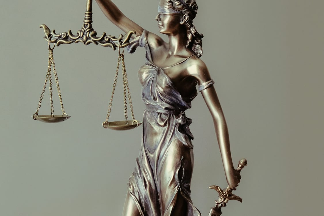 Escultura de la Diosa de la Justicia con balanza y espada, símbolo de asistencia jurídica